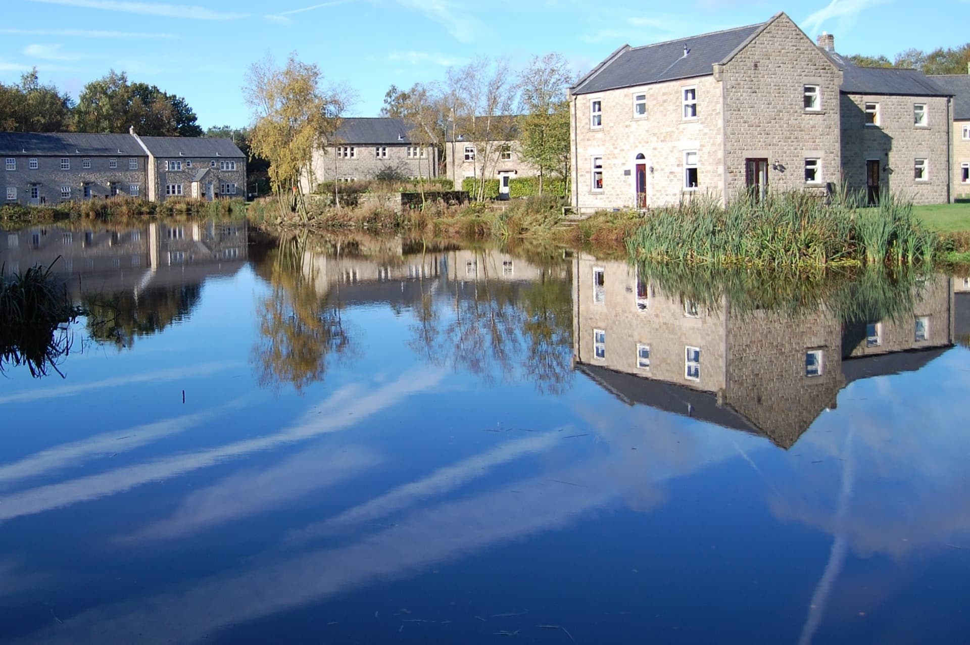 Stone cottages reflected in the still lake at Darwin Lake